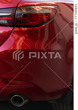 Fragment of a modern red car, rear headlight and bumper 77700891