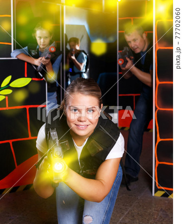 Woman playing lasertag with family Woman playing lasertag with family 77702060