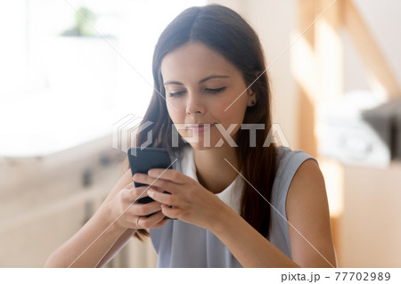Millennial woman use smartphone texting online on gadget 77702989