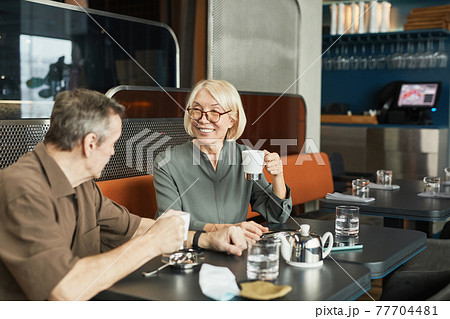 Senior couple chatting in cafe 77704481