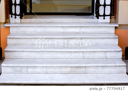 white marble staircase with stone steps at the threshold of the store entrance with glass door close-up of architecture, nobody. white marble staircase with stone steps at the threshold of the store entrance with glass door close-up of architecture, nobody. 77704917