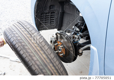 車のタイヤ交換と整備　メンテナンス　（タイヤ交換をする男性） 77705051