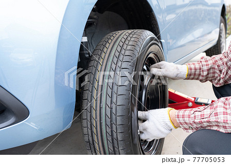 車のタイヤ交換と整備　メンテナンス　（タイヤ交換をする男性） 77705053