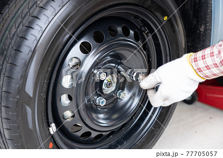 車のタイヤ交換と整備 メンテナンス タイヤのナットを締める男性 の写真素材