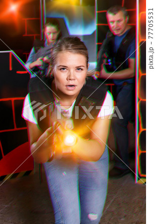 satisfied girl with laser pistol playing laser tag with friends satisfied girl with laser pistol playing laser tag with friends 77705531