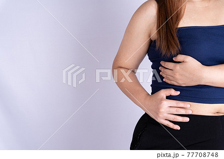 Woman hand touching waist or liver position isolated grey background. Woman hand touching waist or liver position isolated grey background. 77708748
