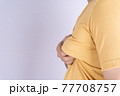 Fat man holding excessive fat boobs isolated grey background. 77708757