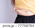 Fat man holding excessive fat belly isolated grey background. 77708764