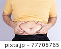Fat man holding excessive fat belly isolated grey background. 77708765