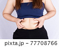 Fat woman holding excessive fat belly isolated grey background. 77708766