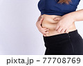 Fat woman holding excessive fat belly isolated grey background. 77708769