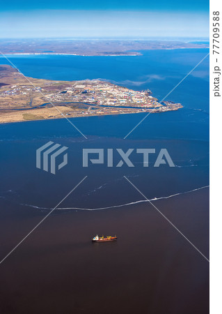 Aerial view of a cargo ship and a small port town in the Arctic 77709588