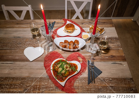 Valentines day dinner setting romantic love for two wooden table red heart shape candle light with Burger and Pasta Valentines day dinner setting romantic love for two wooden table red heart shape candle light with Burger and Pasta 77710083
