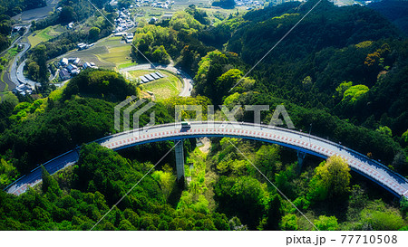 新緑の中をドローンで撮ったコンパスで描いたようなきれいな曲線を描いた空中道路！ 77710508