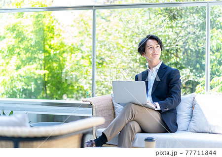 テラスでテレワークをする男性。撮影協力「＋SHIFT NOGIZAKA」 77711844