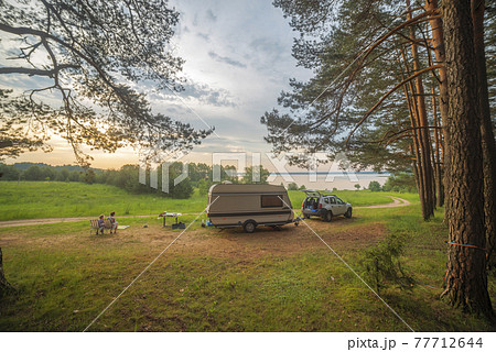 camper in the forest by the lake 77712644