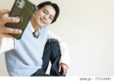 スマホと韓流メイクの男性 スマホと韓流メイクの男性 77714485