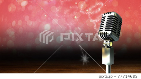 Vintage microphone on a stand over red sparkling background, performance and holiday concepts 77714685