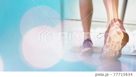 Composition of spots of light over woman running on treadmill with foot bones showing 77715634