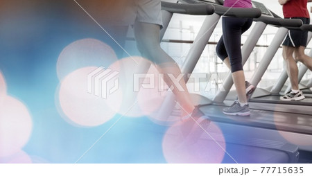 Composition of man running on treadmill with red spot on ankle showing injury with spots of light 77715635
