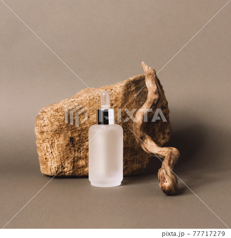 A bottle gel serum of a cosmetic product on the podium made of natural materials 77717279