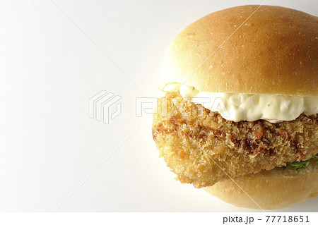 たっぷりのタルタルソースと白身魚のフライがはさまったハンバーガーを白背景で撮影(正面、俯瞰) たっぷりのタルタルソースと白身魚のフライがはさまったハンバーガーを白背景で撮影(正面、俯瞰) 77718651