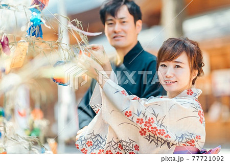 七夕の短冊を飾る男女 77721092