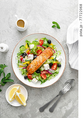 Salmon fish salad. Fresh vegetable greek salad with tomato, pepper, lettuce, olives, cucumbers, feta cheese and grilled salmon fish fillet in bowl, healthy food, omega 3, keto diet, mediterranean Salmon fish salad. Fresh vegetable greek salad with tomato, pepper, lettuce, olives, cucumbers, feta cheese and grilled salmon fish fillet in bowl, healthy food, omega 3, keto diet, mediterranean 77722068