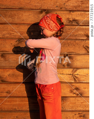 Kid using smartwatch outdoor on wooden background sunny day. Child talking on vdeo call on smartphone. Kid using smartwatch outdoor on wooden background sunny day. Child talking on vdeo call on smartphone. 77723915