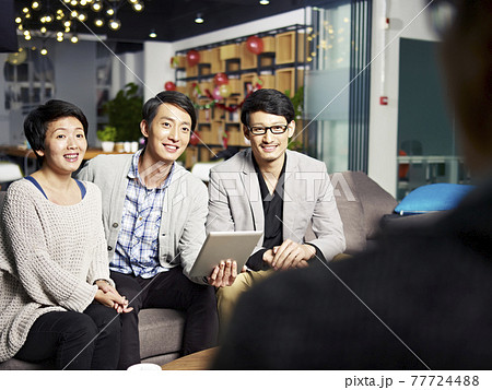 a team of young asian business people talking to boss in office 77724488