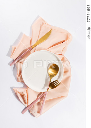 Beautifully decorated table with white plates, golden apple cutlery on luxurious beige tablecloths Beautifully decorated table with white plates, golden apple cutlery on luxurious beige tablecloths 77724693