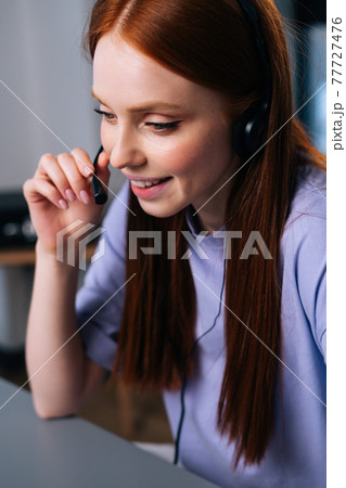 Close-up back view of young woman operator using headset and laptop computer during customer support. Close-up back view of young woman operator using headset and laptop computer during customer support. 77727476