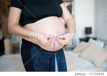 Pregnant woman measuring her belly. Healthy pregnancy. Health pregnancy lifestyle. 77730092