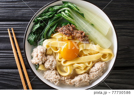 Ban Mian Chinese egg noodle soup with anchovies, meatballs and pak choi close-up in a bowl. horizontal top view Ban Mian Chinese egg noodle soup with anchovies, meatballs and pak choi close-up in a bowl. horizontal top view 77730586