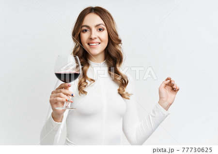 Pretty fashion woman holding glass of red wine on white background 77730625