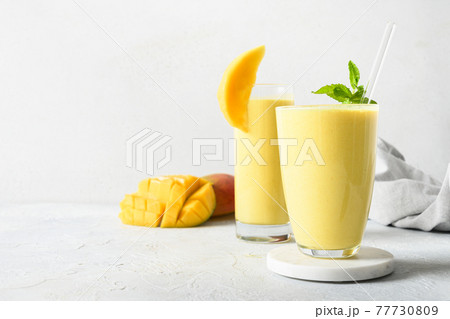 Indian mango or turmeric lassi on gray background Indian mango or turmeric lassi on gray background 77730809