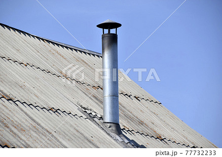 Silver stove pipe in the house against the blue sky 77732233