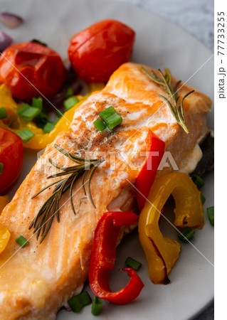 Baked fillet Arctic char on a plate with vegetables 77733255