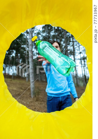 Man throwing a bottle into a trash can 77733967