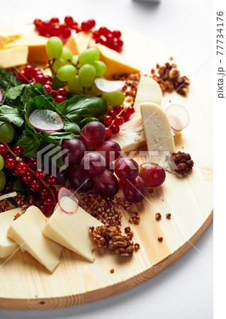 Different varieties of cheese with walnuts and grapes. Different varieties of cheese with walnuts and grapes. 77734176