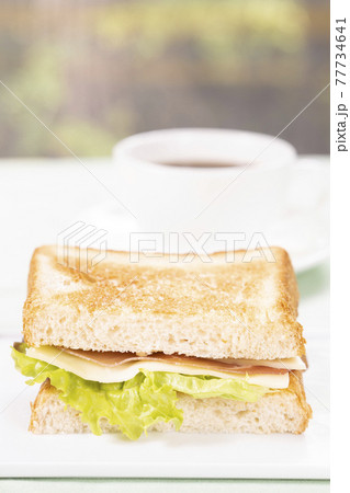 朝食の生ハムチーズサンドとコーヒー 77734641