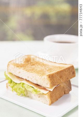 朝食の生ハムチーズサンドとコーヒー 77734643
