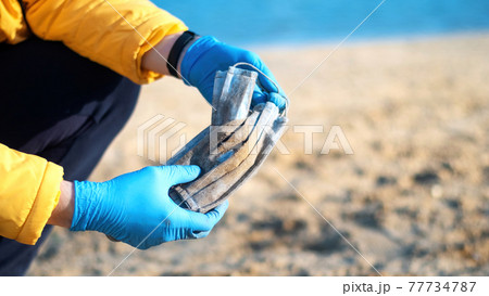 Man picking up dirty medical masks from the ground 77734787