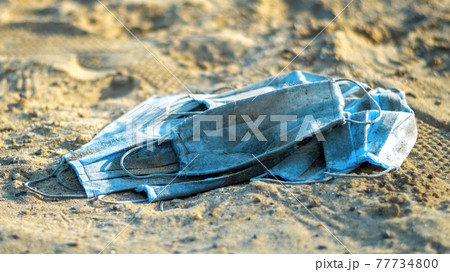 A bunch of medical masks on the beach of a lake A bunch of medical masks on the beach of a lake 77734800