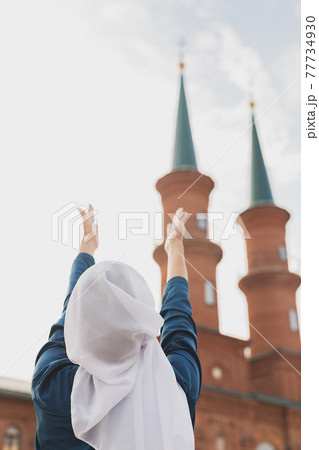 Muslim woman prayer wear hijab fasting pray to allah on mosque background, back view Muslim woman prayer wear hijab fasting pray to allah on mosque background, back view 77734930