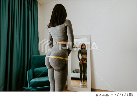 attractive slim Woman Measuring body With Tape at home attractive slim Woman Measuring body With Tape at home 77737289