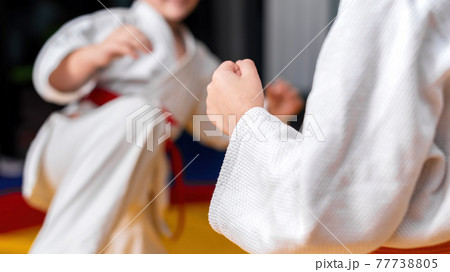 Two boys practice martial arts in a gym Two boys practice martial arts in a gym 77738805