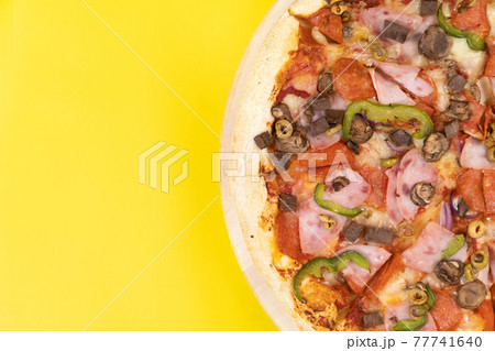 Delicious large pizza with veal and mushrooms on a yellow background 77741640
