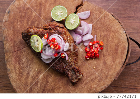 Fried Fermented Fish, Pickled Fish on a Wooden Table in the Kitchen for Lunch. Fried Fermented Fish, Pickled Fish on a Wooden Table in the Kitchen for Lunch. 77742171