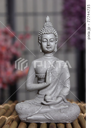 Buddha Statue in Asian Style Room With Cherry Blossoms in Background Buddha Statue in Asian Style Room With Cherry Blossoms in Background 77744735